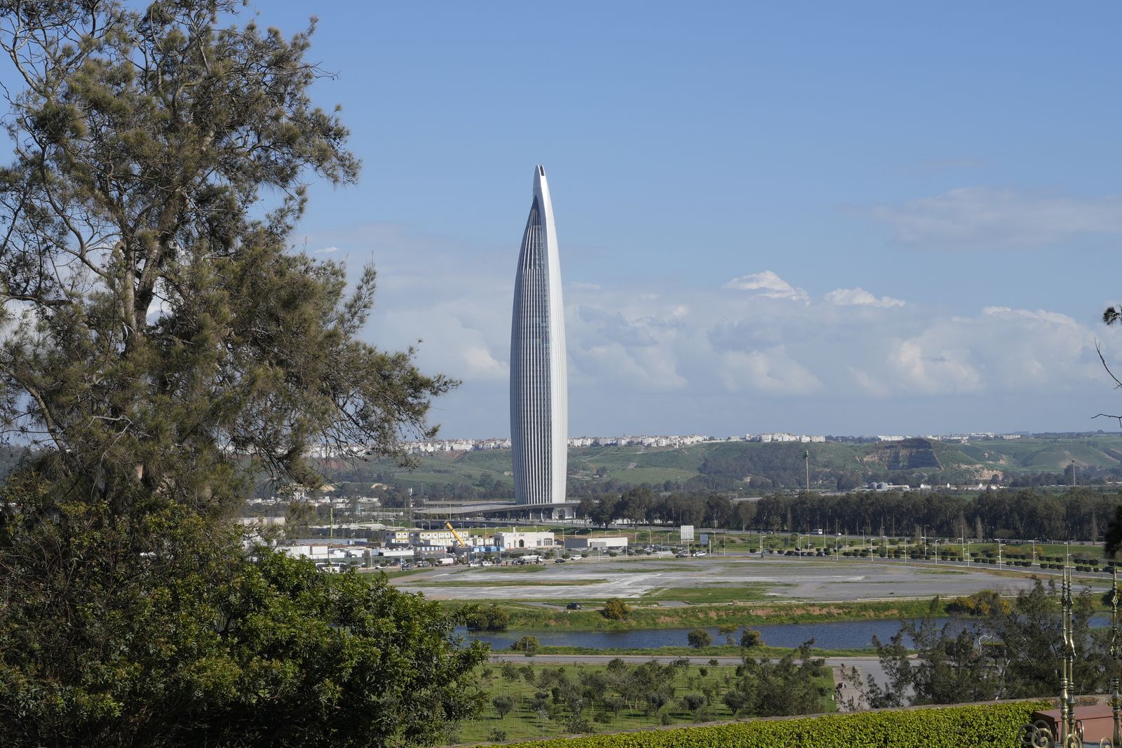 La tour Mohammed VI à Rabat, vue depuis un parc, sous un ciel dégagé.